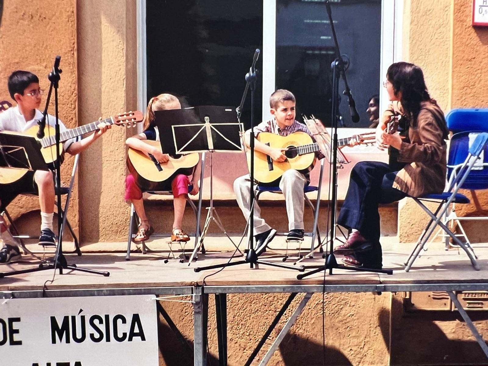 Fran Pradas de niño tocando la guitarra española en una actuación de la escuela de música